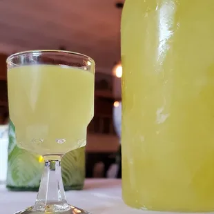 a glass of lemonade next to a bottle of lemonade