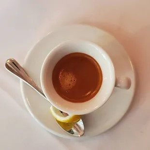 a cup of hot chocolate with a lemon wedge