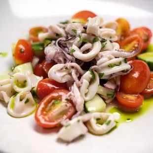 a plate of squid and tomato salad