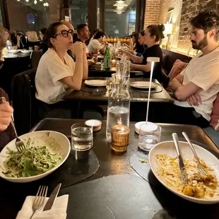 What's wrong with this picture? Only two diners have their pastas at our table. The other diners have empty plates and unhappy expressions.