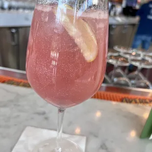 a glass of wine with a slice of lemon