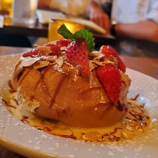 Floating island with strawberries. Meringue in a crispy coat with almond and strawberry slices in crème anglaise sauce.