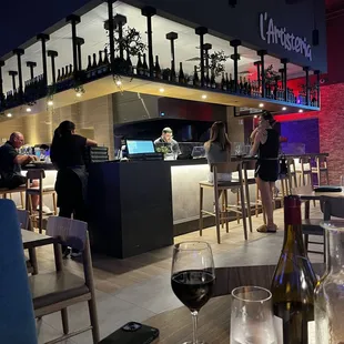 a woman sitting at a table with a glass of wine