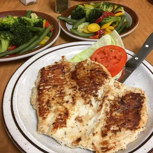 Grilled chicken dinner with sides of steamed veggies