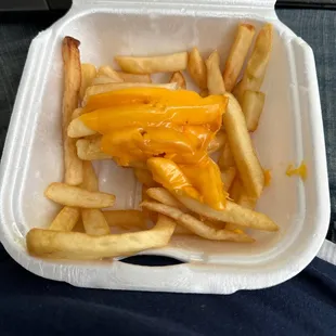 cheese fries in a styrofoam container