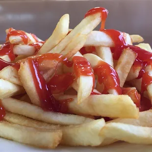 a pile of french fries with ketchup and ketchup