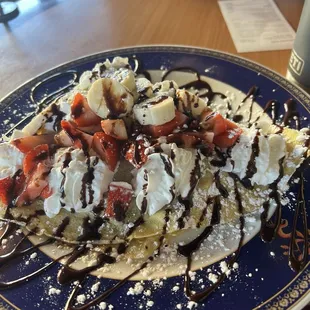Bananas, strawberries, Nutella crepe topped with whip cream and drizzle with chocolate syrup.