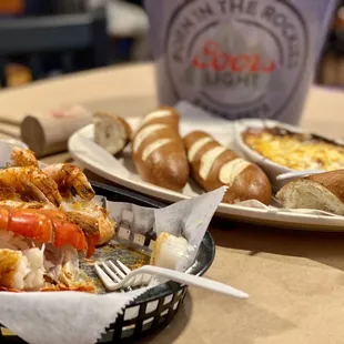 Half-eaten lobster tail, shrimp, and scallops. Bavarian pretzels with crab dip and the shell pale.