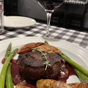 Filet with red wine reduction served with baked potatoes and asparagus