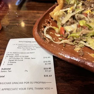 a plate of food and a receipt on a table