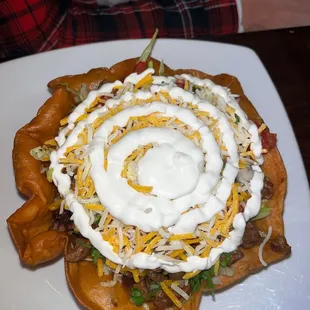 Taco salad with steak beans cheese lettuce cilantro onion sour cream