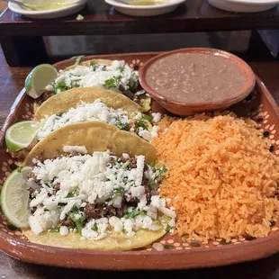 3 Tacos with rice and refried beans.