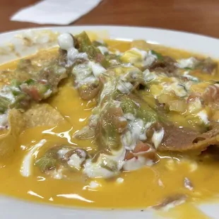 "Nachos" with watery cheese and brown guacamole