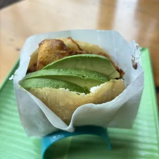 an avocado in a basket on a green tray