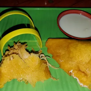 a green plate with a banana and a cup of yogurt