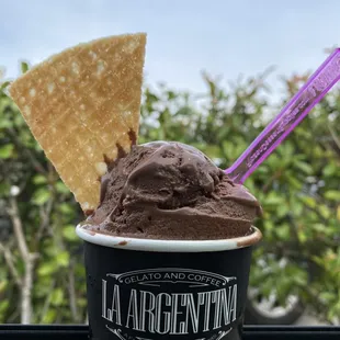 a cup of ice cream with a spoon sticking out of it