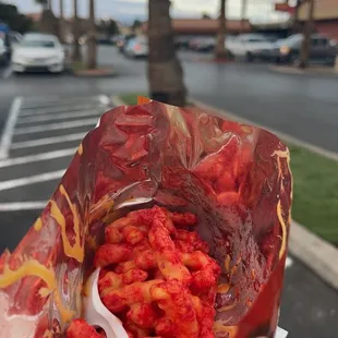 a hand holding a bag of chicken wings