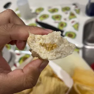 a hand holding a piece of bread