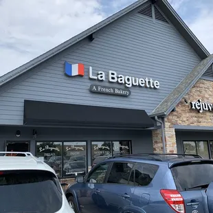 cars parked in front of a french bakery