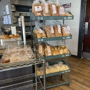Whole loaves of fresh baked bread. Baguettes are at the front on top of the counter.