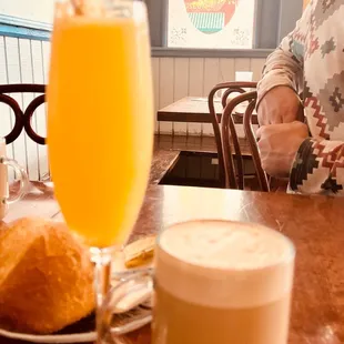 a woman sitting at a table with a glass of orange juice