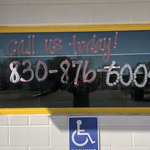 a sign in a window that says call us today