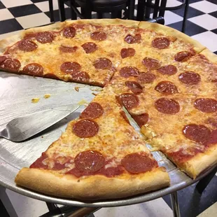 a pepperoni pizza on a pizza pan