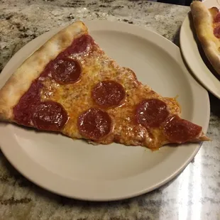 a slice of pepperoni pizza on a plate