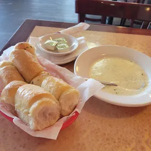 a bowl of soup and rolls