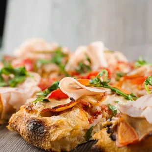 Pinsa romana cut into pieces portions for one person. Pinsa with meat, arugula, cheese. Scrocchiarella gourmet