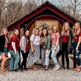 a group of women standing in front of a barrel