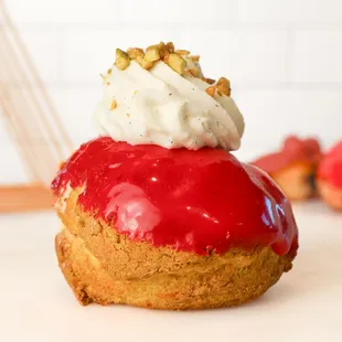 Le Chou de L&apos;ètè- This summer dessert has a pâte a choux base with sweet craquelin, filled with strawberry mousse and pistachio paste.