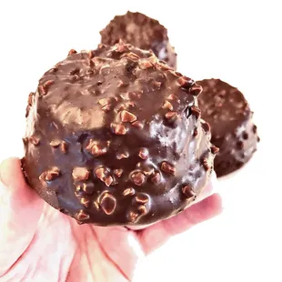 a hand holding a chocolate donut