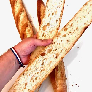 a hand holding a piece of bread