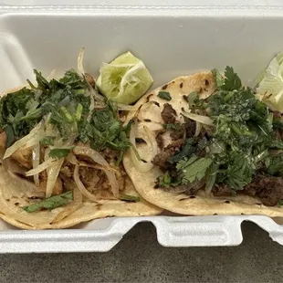 Tacos de al pastor y de asada con cebolla asada y cilantro.