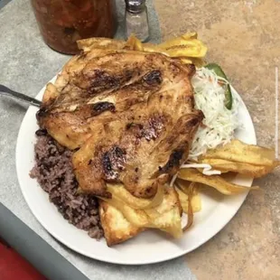 Pollo asado Nicaragüense: Pollo asada, gallopinto, repollo, Tajadas, y queso frito