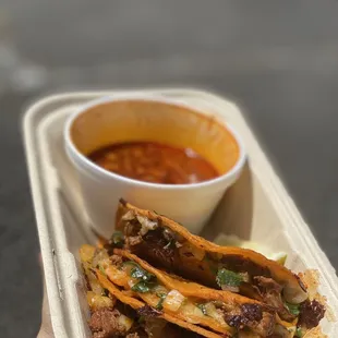 a hand holding a container of food