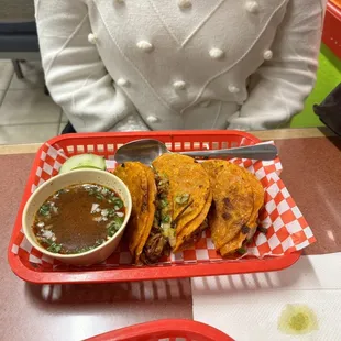 a basket of tacos and a bowl of salsa