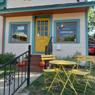 a yellow table and chairs outside a restaurant