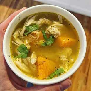 a person holding a bowl of soup