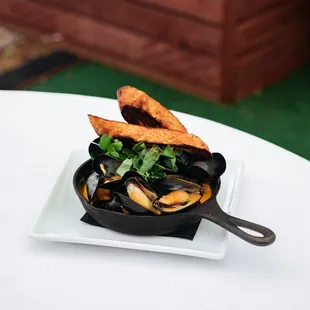 Happy Hour Steamed Mussels with coconut, red curry, cilantro, basil, mint, chorizo, &amp; baugette
