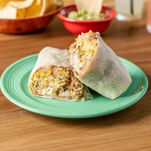 a burrito cut in half on a green plate