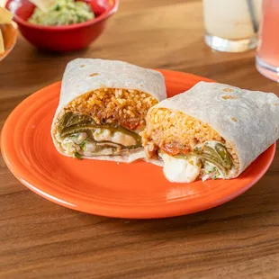 a burrito on an orange plate with chips