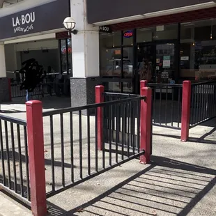 the shadow of a gate in front of a restaurant