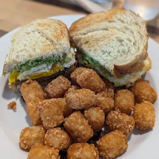 Breakfast sandwich ( sausage, egg cheese and avocado) with tater tots
