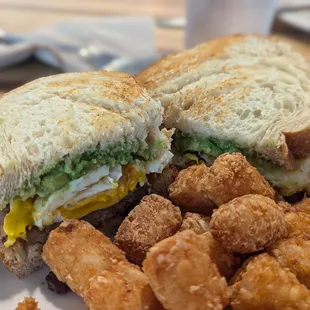 Breakfast sandwich ( sausage, egg cheese and avocado) with tater tots