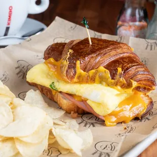 a croissant sandwich and chips