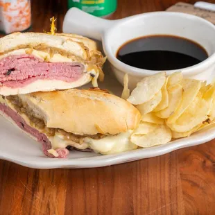 Signature French Dip roast beef sandwich on fresh-baked baguette with au jus dip.