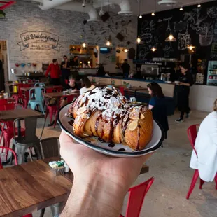 a person holding a plate of french toast