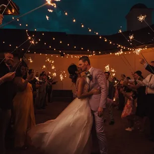 a bride and groom kissing while surrounded by sparklers